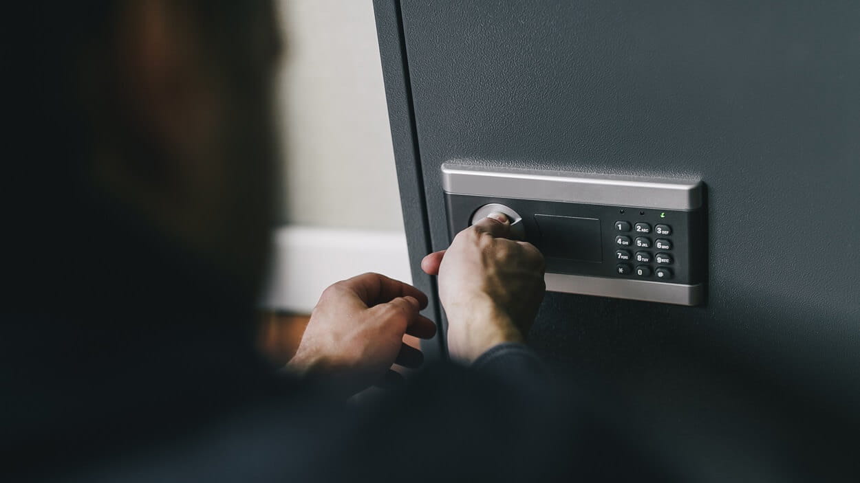 Man opening safe to add money he's saving with the DSV Electronic bond store solution in South Africa